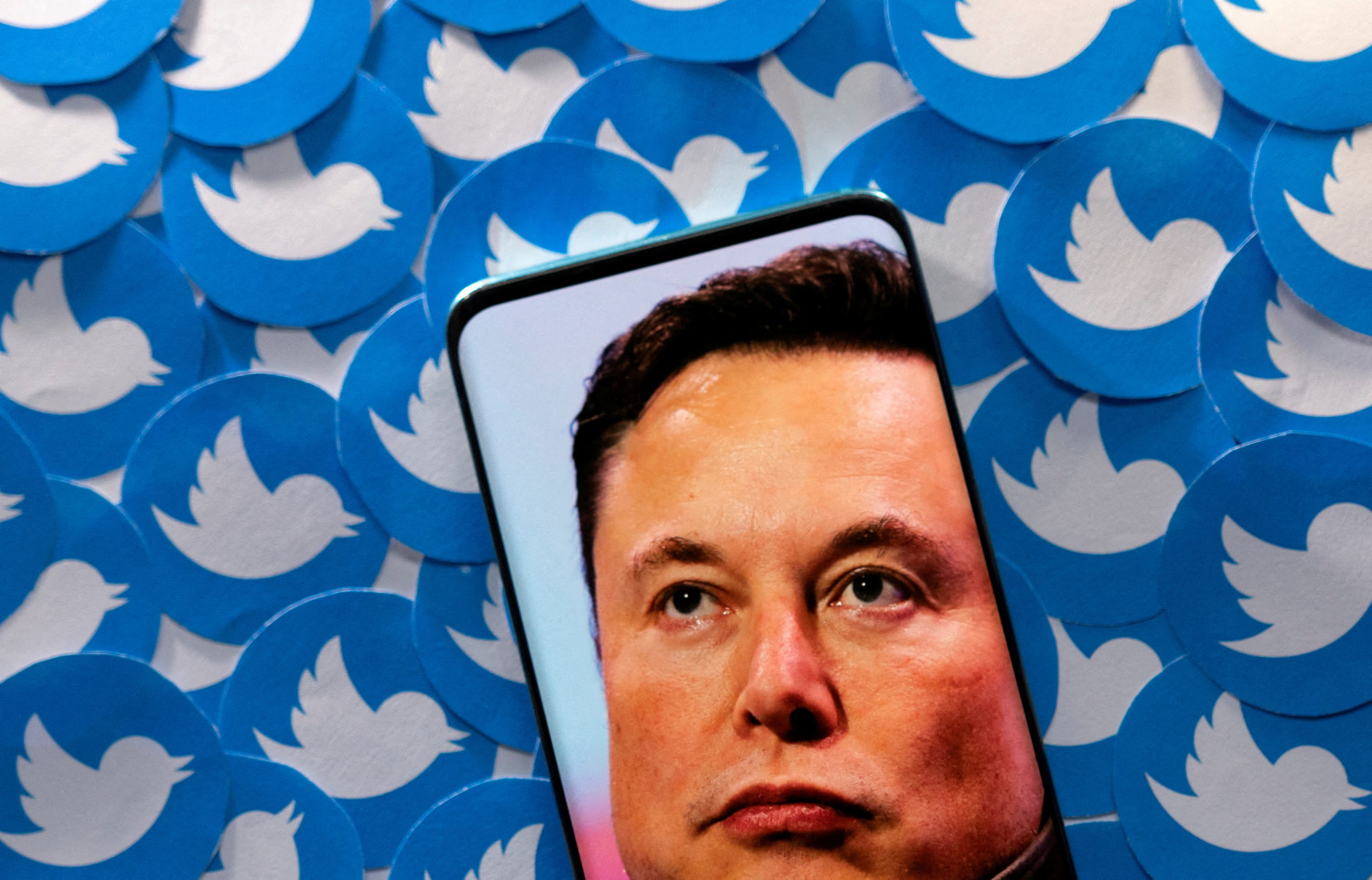 file photo illustration shows elon musk image on smartphone and printed twitter logos 