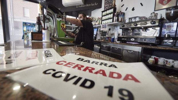 ep archivo   un camarero coloca carteles en su barra cerrada por covid