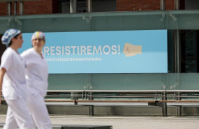 ep cartel en el que se lee resistiremos en el exterior del hospital de campana de ifema en el que