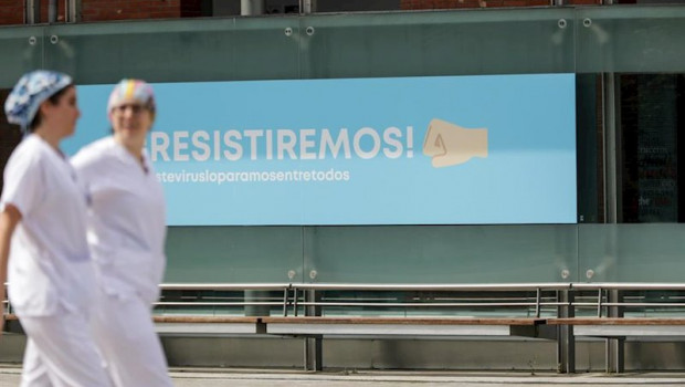 ep cartel en el que se lee resistiremos en el exterior del hospital de campana de ifema en el que
