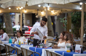 ep un camarero atendiend a unos clientes