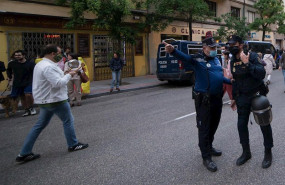 ep un agente de policia municipal hace indicaciones a uno de policia nacional en una protesta en la