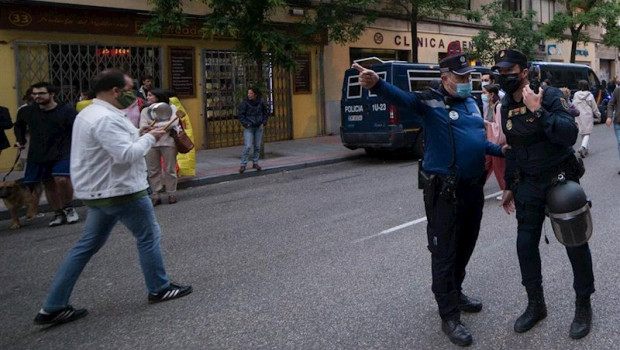 ep un agente de policia municipal hace indicaciones a uno de policia nacional en una protesta en la