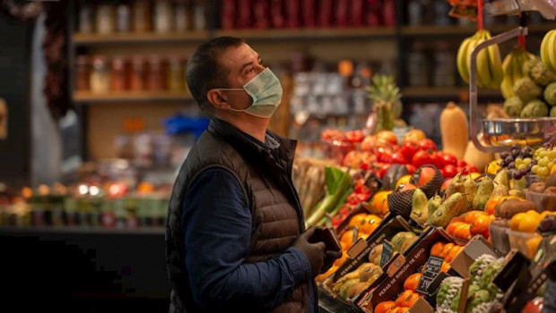 ep un hombre protegido con mascarilla es atendido en una fruteria en barcelona espana
