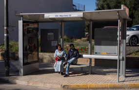 ep archivo   dos personas esperan un autobus en una parada de massamagrell el dia 13 tras el paso de