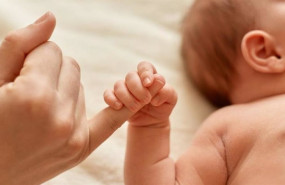 ep un bebe agarra el dedo de su madre
