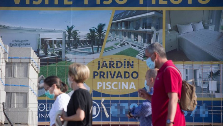 Varias personas caminan junto a un cartel de viviendas en venta. | Carlos Castro - Europa Press - Archivo ep varias personas caminan junto a un cartel de viviendas en venta