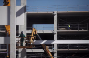 ep varios obreros trabajan con maquinaria de construccion en las obras del nuevo hospital de