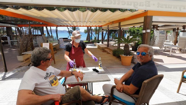 ep 20 may 2020 spain calvia a waitress serves beer to customers at the essbar restaurant terrace on