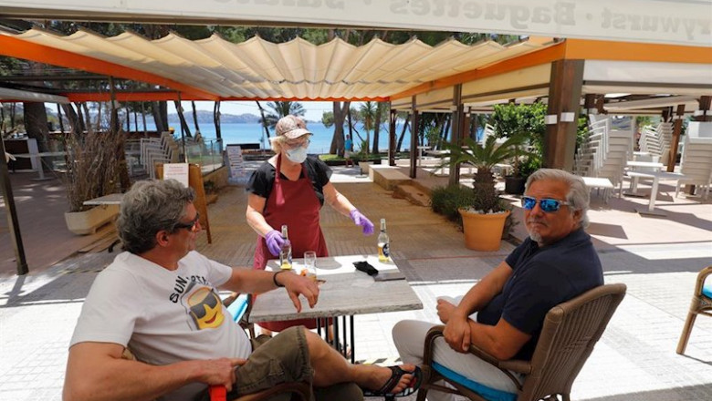 ep 20 may 2020 spain calvia a waitress serves beer to customers at the essbar restaurant terrace on