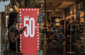 ep archivo   una mujer pasa al lado de una tienda en rebajas