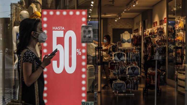 ep archivo   una mujer pasa al lado de una tienda en rebajas
