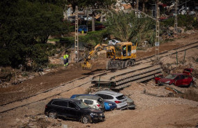 ep una maquina trabaja en la reparacion de las vias del tren de alfafar donde permanecen vehiculos