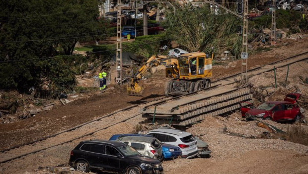 ep una maquina trabaja en la reparacion de las vias del tren de alfafar donde permanecen vehiculos