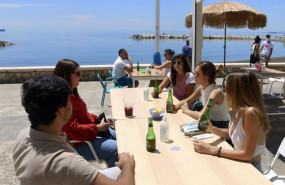 ep varias personas disfrutan de la terraza de un bar en el paseo maritimo en malaga