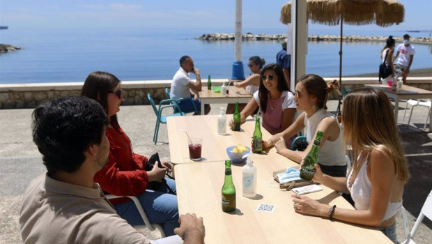 ep varias personas disfrutan de la terraza de un bar en el paseo maritimo en malaga