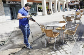 ep un trabajador desinfecta la terraza de un restaurante antes de reabrir sus puertas