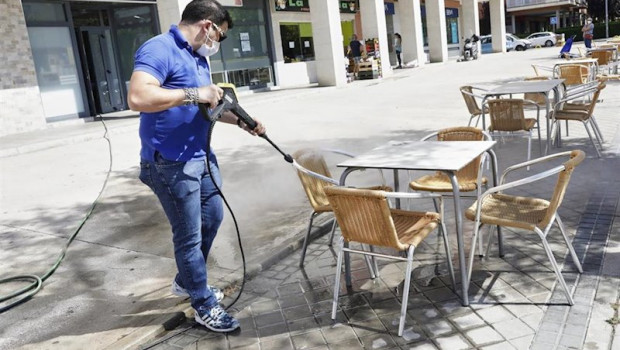 ep un trabajador desinfecta la terraza de un restaurante antes de reabrir sus puertas