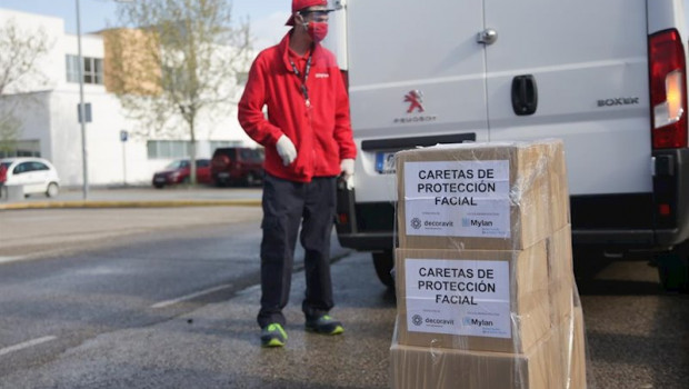 ep un trabajador protegido con mascarilla deja unas cajas con caretas de proteccion facial