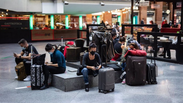 ep archivo   varias personas esperan la llegada de sus trenes en la estacion de madrid   puerta de