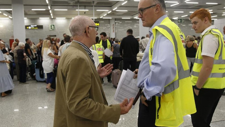 Un turista habla con dos guardas de seguridad mientras se forman largas colas en las ventanillas del aeropuerto de Palma de Mallorca (Baleares), horas después de que la compañía británica Thomas Cook anunciase su quiebra y de que varios de sus vuelos fues | Isaac Buj - Europa Press ep un turista habla con dos guardas de seguridad mientras se forman largas colas en las ventanillas