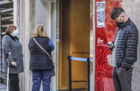 ep archivo   un joven mira su telefono movil mientras espera para entrar en una oficina del sepe en