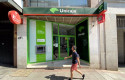 ep archivo   una persona pasa por delante de una oficina de unicaja