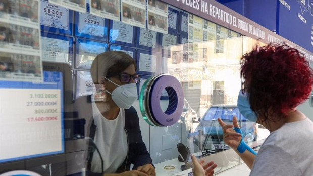 ep una lotera de una administracion de loteria en manises atiende a una clienta durante el cuarto