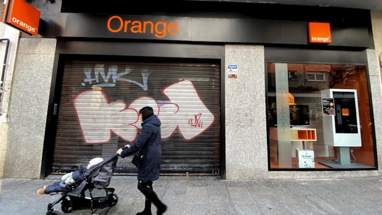 ep una mujer pasea frente a una tienda de de la compania telefonica orange ep una mujer pasea frente a una tienda de de la compania telefonica orange