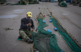 ep archivo   un pescador remienda sus redes de pesca en la lonja pesquera de la cofradia de