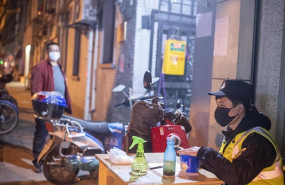 ep february 10 2020 shanghai china - a security guard in a surgical mask sitsbehind a table at the ep february 10 2020 shanghai china - a security guard in a surgical mask sitsbehind a table at the