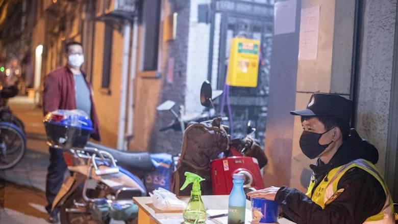 ep february 10 2020 shanghai china - a security guard in a surgical mask sitsbehind a table at the