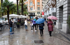 ep varias personas pasean por la calle con un paraguas debido a la lluvia durante el peor temporal
