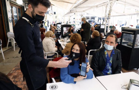 ep un camarero pide certificado a los clientes en una mesa en la terraza de un bar