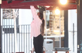 ep archivo   una camarera colocando la sombrilla en la terraza de un bar