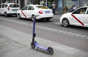 ep un patinete electrico aparcado frente a unos taxis en las inmediaciones de la puerta del sol de
