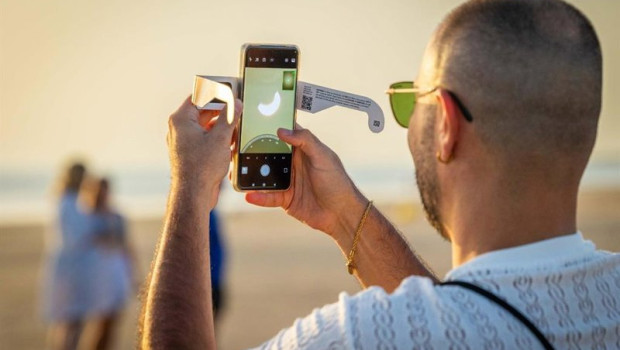 ep una persona hace una foto del eclipse con su movil en la playa de camposoto en san fernando cadiz