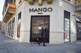 ep una mujer pasea a su perro delante de la tienda mango cerrada durante el termino de la segunda