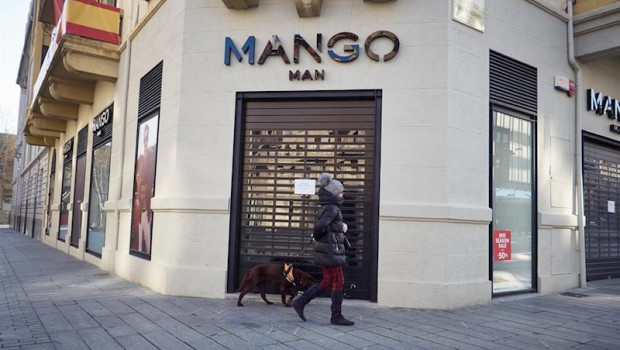 ep una mujer pasea a su perro delante de la tienda mango cerrada durante el termino de la segunda