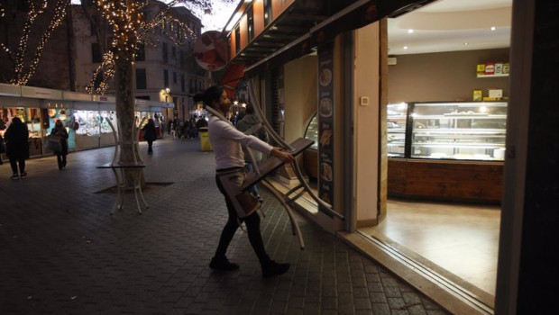 ep una camarera recoge las mesas de la terraza de una cafeteria en palma de mallorca
