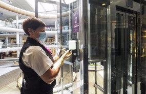 ep una trabajadora de la limpieza coloca un recambio de gel desinfectante en un dispensador