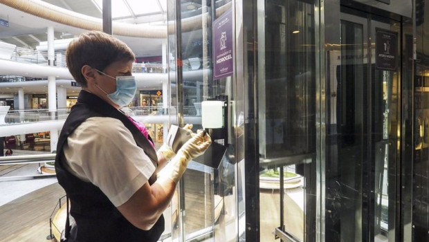 ep una trabajadora de la limpieza coloca un recambio de gel desinfectante en un dispensador