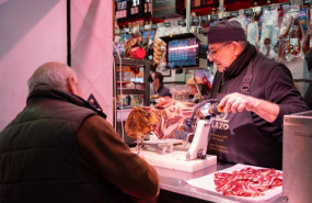 ep archivo   un autonomo atendiendo a un cliente en su puesto de un mercado de abastos de sevilla
