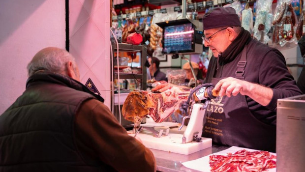 ep archivo   un autonomo atendiendo a un cliente en su puesto de un mercado de abastos de sevilla