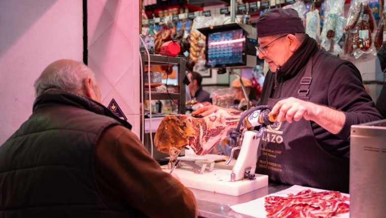 ep archivo   un autonomo atendiendo a un cliente en su puesto de un mercado de abastos de sevilla