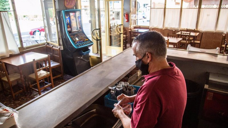 Un camarero seca varios vasos en un bar | JAVIER PULPO - Europa Press ep un camarero seca varios vasos en un bar