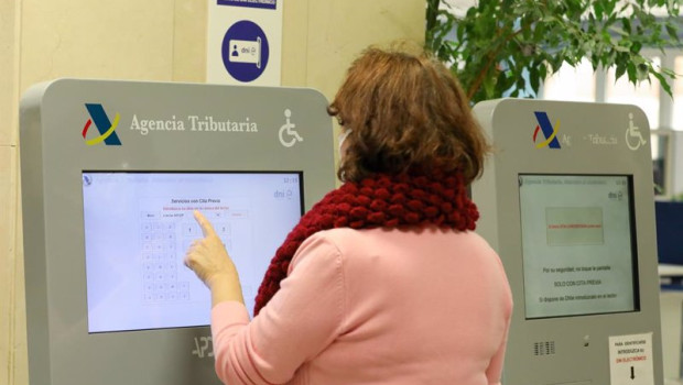 ep archivo   una mujer recoge su turno en una oficina de la agencia tributaria